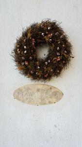 a wreath with a plate on a white wall at Villa Maria υπέροχη βίλα στα Μετέωρα in Kalabaka