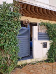 uma porta de garagem azul em frente a um edifício em Maison Brisson em Talence