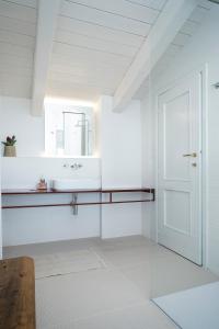 Baño blanco con lavabo y espejo en Casa Kiko Pecetto, en Pecetto