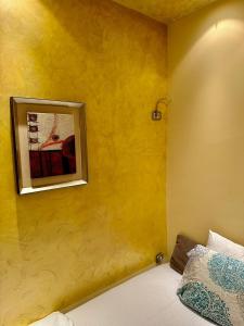 Habitación amarilla con cama y una foto en la pared en Studio Duet 2002 en Budva
