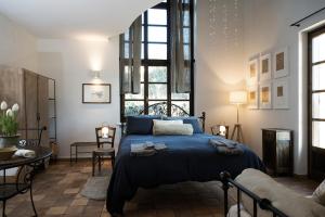 sypialnia z łóżkiem z niebieską narzutą w obiekcie Casa Kiko Pecetto w mieście Pecetto