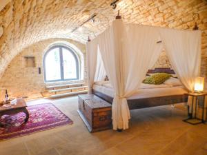 een slaapkamer met een hemelbed in een bakstenen muur bij Haus Mandelblüte in Gimmeldingen