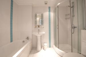 a white bathroom with a sink and a shower at Woodlands Hotel in Bartley +72 photos