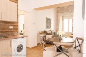 Living4Malaga Boutique Apartments في مالقة: مطبخ وغرفة معيشة مع طاولة وغرفة طعام