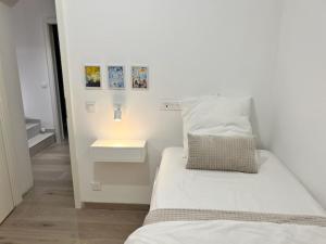 a small bedroom with two beds and a night stand at Le retour in Saint-Cyr-sur-Mer