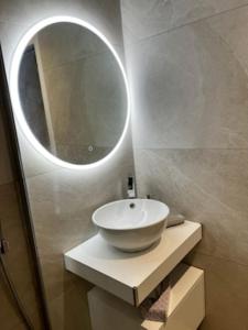 濱海聖西的住宿－Le retour，一间带水槽和圆镜子的浴室