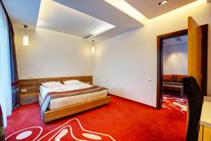 a bedroom with a bed and a mirror in it at Hotel Ave Lux in Braşov