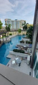 a swimming pool with tables and chairs and a building at Tira Tiraa Condominium in Hua Hin