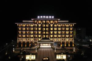 Pengze的住宿－彭泽远洲轩廷酒店，一座大建筑,上面有灯,晚上