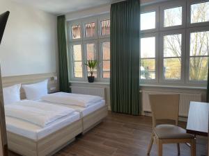 1 dormitorio con 2 camas, mesa y silla en Lokschuppen Pasewalk- Gästehaus Lokschuppen en Pasewalk