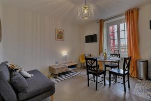 a living room with a couch and a table with chairs at Les Mots Bleus in Dinard