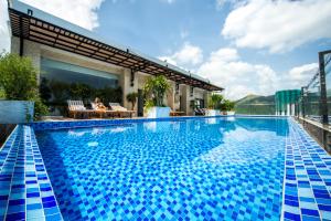 a swimming pool with blue tiles on a building at Putin Hotel Nha Trang in Nha Trang