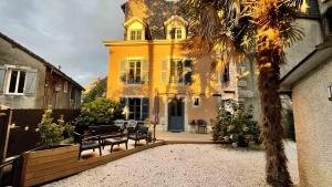 ein gelbes Haus mit einer Bank davor in der Unterkunft Maison dans le centre historique pour 6 personnes avec terrasse et parking in Pau