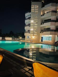 uma piscina em frente a um edifício à noite em Rayong Condo Chain studio room em Ban Pak Khlong Phe