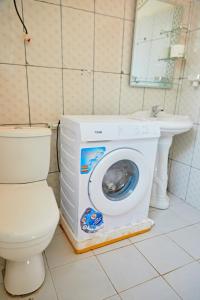 uma máquina de lavar roupa na casa de banho ao lado de um WC em Appartement Avec vue panoramique em Yaoundé