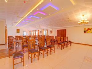 トリバンドラムにあるPallava Rajadhaniの椅子とテーブルが並ぶ部屋