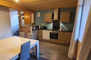 a kitchen with a table and a dining room at Appartement 6/8 personnes in Petite Chaux