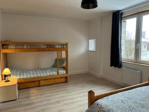 a bedroom with two bunk beds and a window at Appartement 6/8 personnes in Petite Chaux