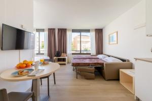 ビラノバ・イ・ラ・ジャルトルにあるAtenea Park Suites & Apartmentsのベッドとテーブルが備わるホテルルームです。