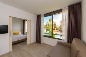 a hotel room with a bed and a large window at Atenea Park Suites & Apartments in Vilanova i la Geltrú +37 photos