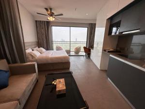 un soggiorno con letto, divano e tavolo di 21st Floor SkyStudio Suite with Balcony a Nuova Delhi