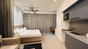 a hotel room with a bed and a kitchen at 21st Floor SkyStudio Suite with Balcony in New Delhi