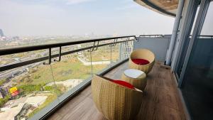 a balcony with two chairs and a view of a city at 21st Floor SkyStudio Suite with Balcony in New Delhi