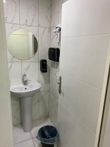 Baño blanco con lavabo y espejo en Deeps Hostel Ankara 2 en Ankara