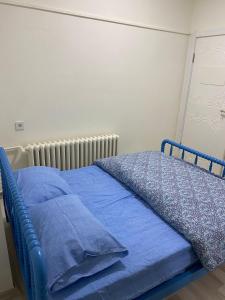 Una cama azul con sábanas y almohadas azules. en Deeps Hostel Ankara 2, en Ankara