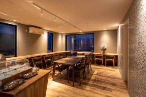 a restaurant with a table and chairs and windows at HOTEL COCOA RESORT in Lake Toya