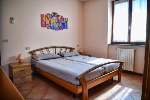 a bedroom with a bed and a painting on the wall at Casa Alex by Wonderful Italy in Gera Lario