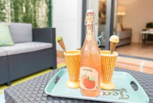 uma garrafa de refrigerante e duas chávenas numa mesa em Apartamento con jardin privado y portero (B) em Madri