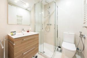 uma casa de banho com um chuveiro, um WC e um lavatório. em Apartamento con jardin privado y portero (B) em Madri