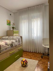 un dormitorio con cama y una pelota de fútbol en una alfombra en 80 m2 recién reformado, acogedor y elegante., en Balmaseda