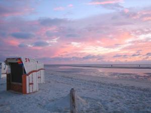 a life guard shack on the beach at sunset at Schaar in Nebel +15 photos