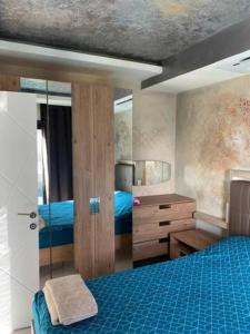 um quarto com uma cama azul e uma cómoda em EGE BIRLIK em Kusadasi
