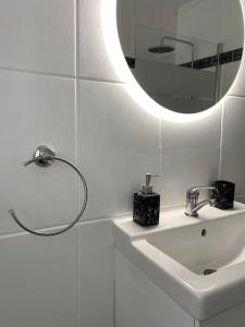 a white bathroom with a sink and a mirror at 80 m2 recién reformado, acogedor y elegante. in Balmaseda