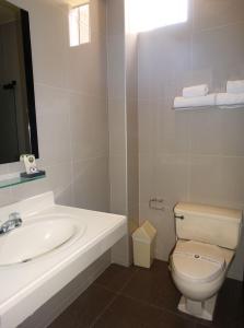 a white bathroom with a sink and a toilet at Hotel Gran Sipan in Chiclayo