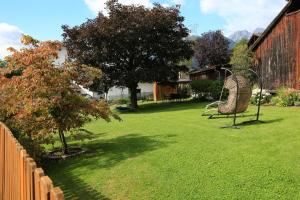 einen Hof mit einem Zaun und einem Stuhl im Gras in der Unterkunft Apartment Edith in Telfes im Stubai