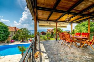 a patio with a table and chairs next to a swimming pool at Villa Lake View in Ohrid