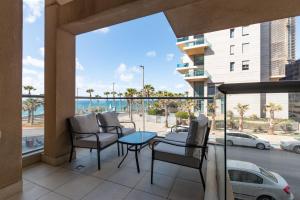 balcón con sillas, mesa y vistas al océano en O&O Group - Stylish & Cozy Seaview Vacation APT, en Bat Yam