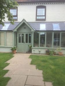 una casa con una porta verde e finestre di HENWICK HOUSE Beautiful flat,Private parking, short walk to town a Ludlow