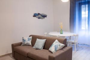 een woonkamer met een bank en een tafel bij Blu Mare Apartment in Alghero