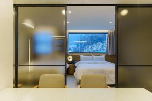 a bedroom with a bed and two chairs at Eden Foret Hotel in Chungju