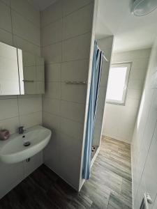 ブレーマーハーフェンにあるMonteurwohnungen Hanseatの白いバスルーム(シンク、シャワー付)