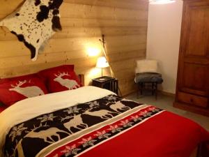 a bedroom with a bed with red pillows and a wall at Chalet Eterlou in Mégevette