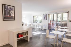 a dining room with white tables and chairs at Hotel Abrial by Soniho in Cannes