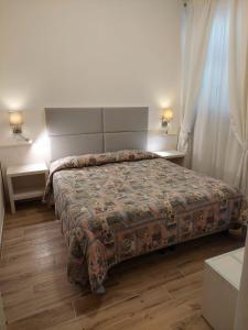 een slaapkamer met een bed en twee tafels en twee lampen bij Hotel Patrizia in Marina di Massa
