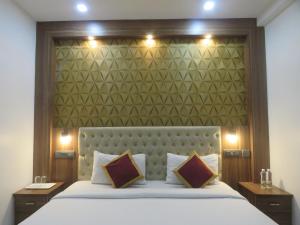 a bedroom with a large bed with a large headboard at Hotel Reegate Inn in Cochin