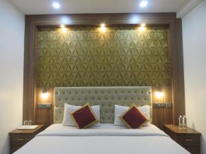 a bedroom with a large bed with a large headboard at Hotel Reegate Inn Near South Railway Station in Cochin
